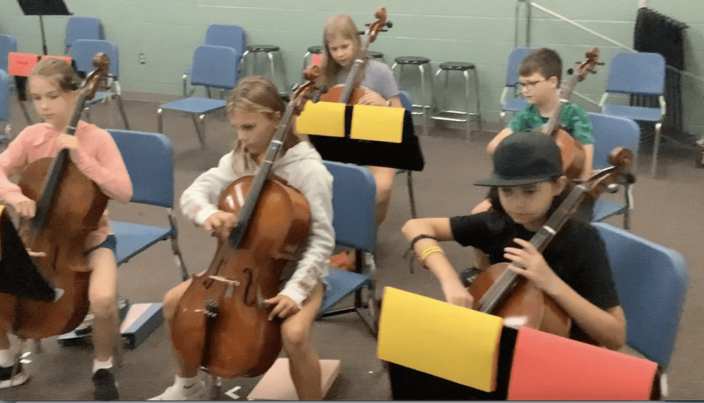 Picture of Tharp students plucking their instruments.