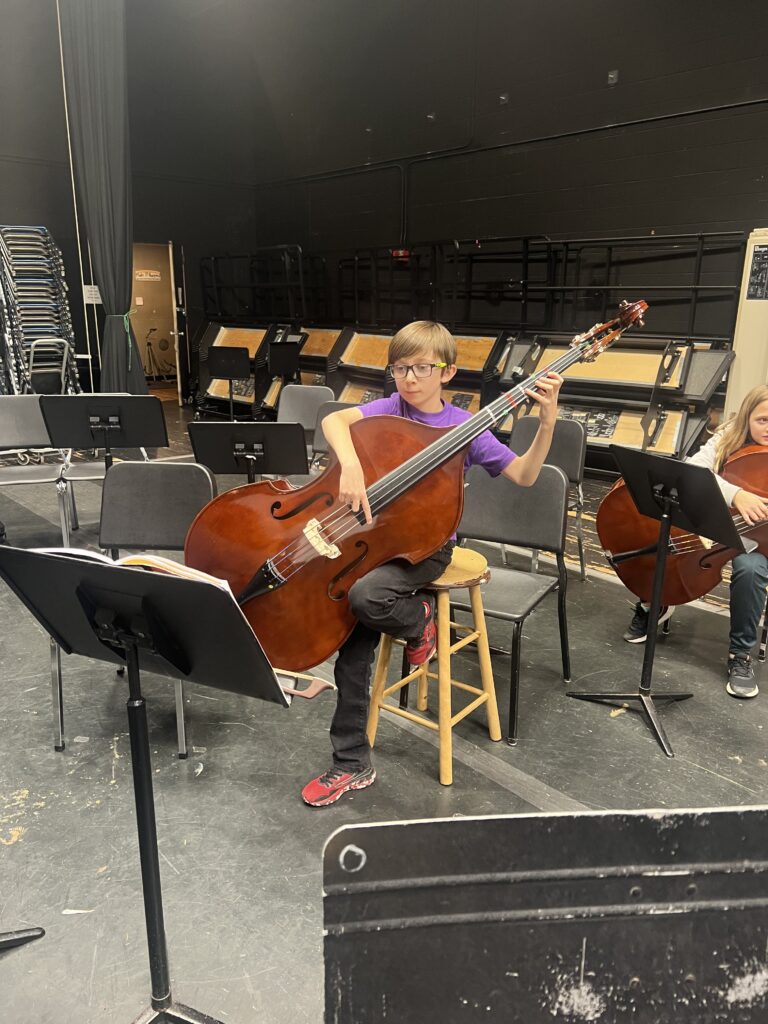 Station Orchestra Student playing bass being silly