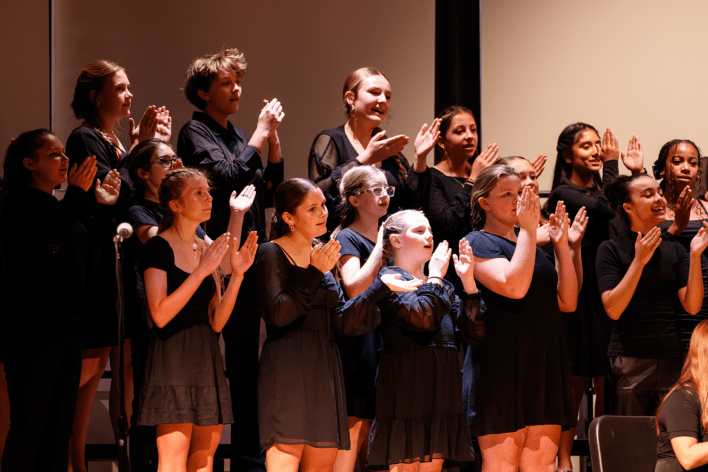 Children in a choir singing and clapping